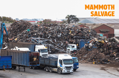 Photo of a scrap yard with piles of scrap metal and HGVs