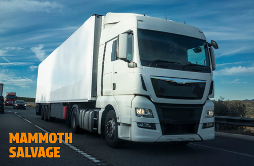 Photo of an HGV driving on a road with a graphical overlay of text saying MAMMOTH SALVAGE