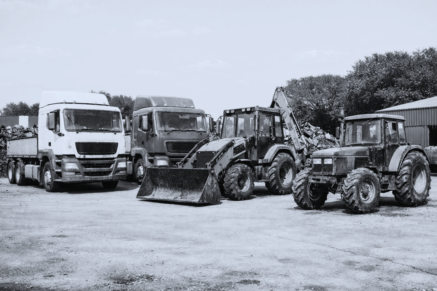 Black and white photo of HGVs and tractors in a scrap yard